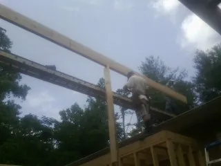 Carpenter setting a ridge beam over a new addition frame — Ice Dam Removal by Roofing Brothers in Grafton