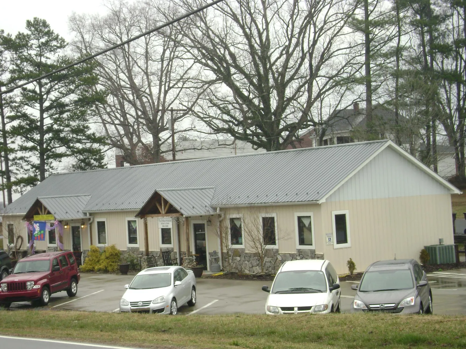 Gray metal roof with timber entry brackets on a small commercial building in Grafton